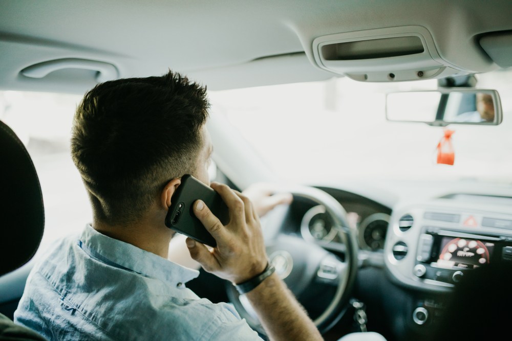 Driver holding a phone to his ear while driving in Atlanta