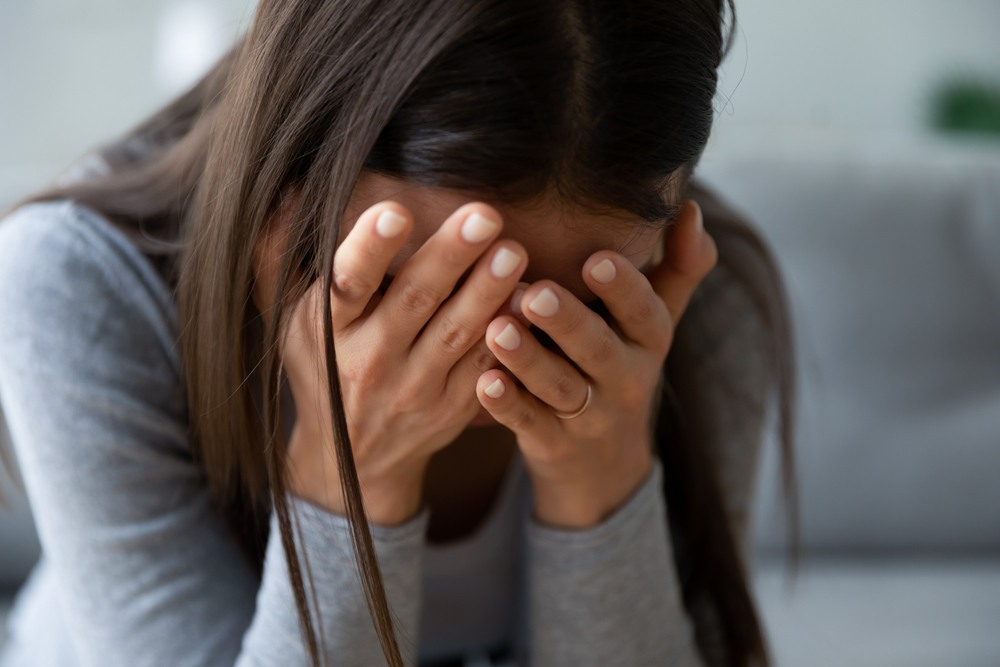 Woman with her head in her hands, visibly grieving