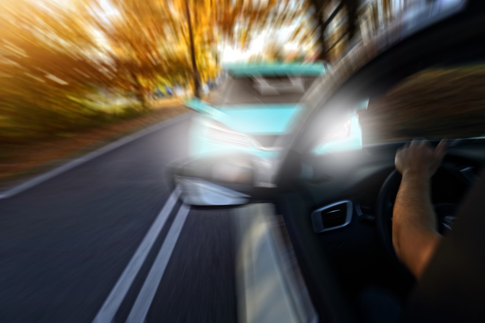Driver's view of an oncoming car crossing into the wrong lane on a two-lane road