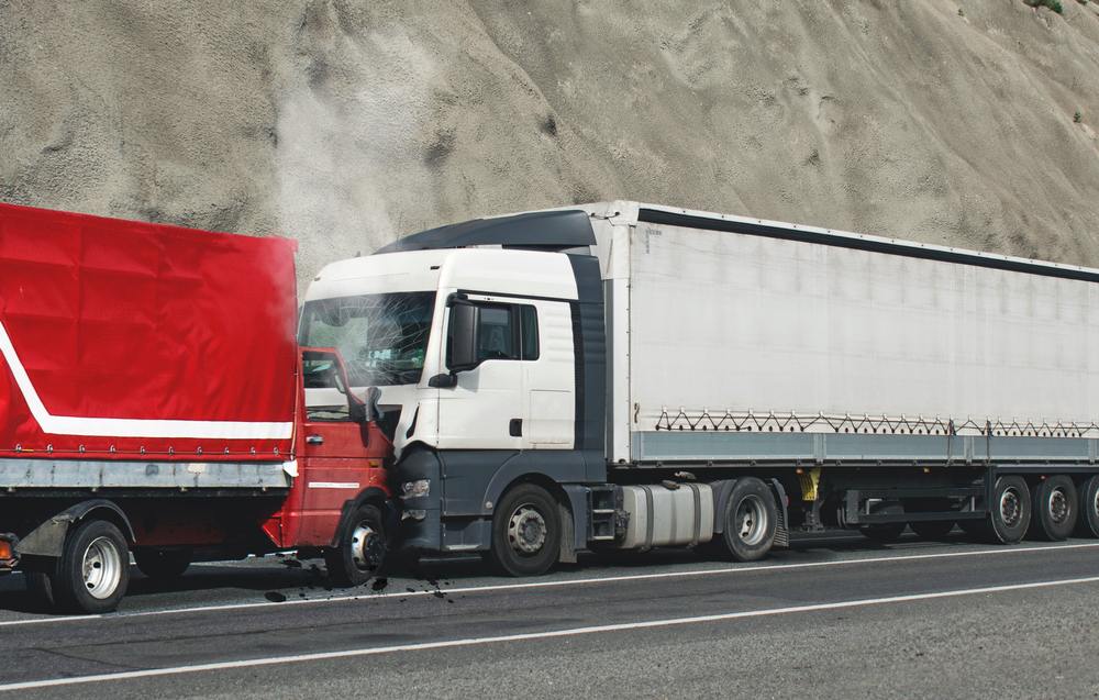 Semi-truck with a damaged windshield after colliding with the back of another truck