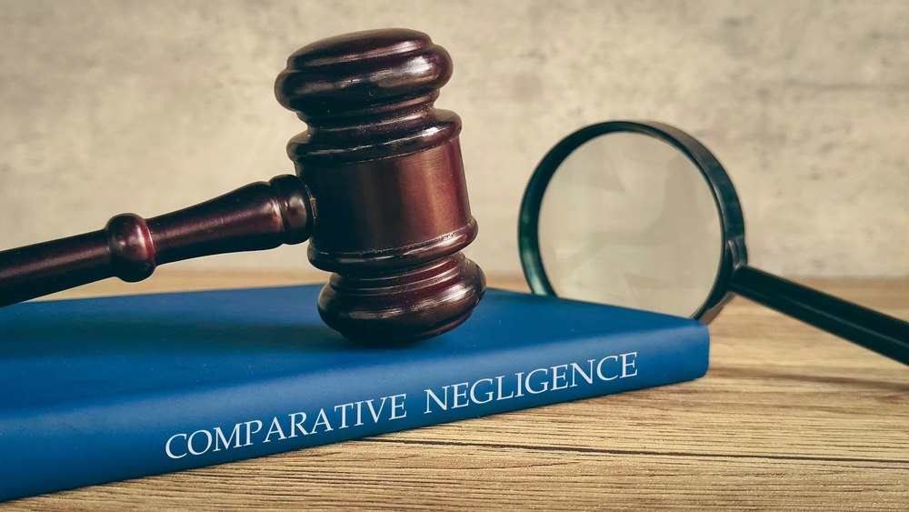 Gavel and magnifying glass resting on a book titled Comparative Negligence
